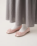 Ballerines Yubi roses portées avec une jupe grise