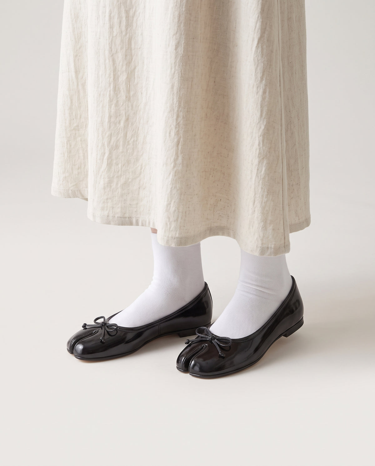 Ballerines Yubi vernies portées avec une jupe écrue