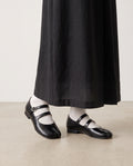 Mary-Janes Yubi noires portées avec des chaussettes blanches